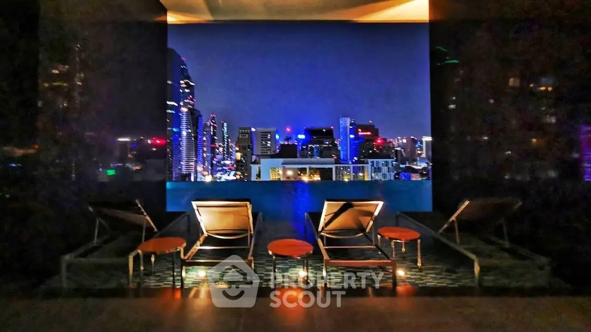 Stunning rooftop view with city skyline and luxurious lounge chairs at night