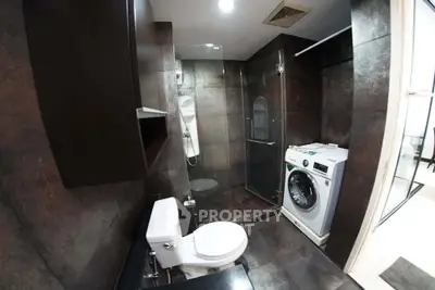 Modern bathroom with washing machine and glass shower enclosure