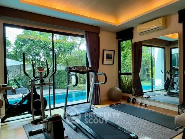 Luxurious home gym with pool view, featuring modern equipment and serene ambiance.