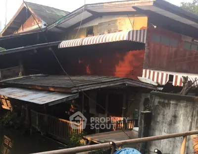 Charming rustic riverside house with striped awnings and wooden facade.