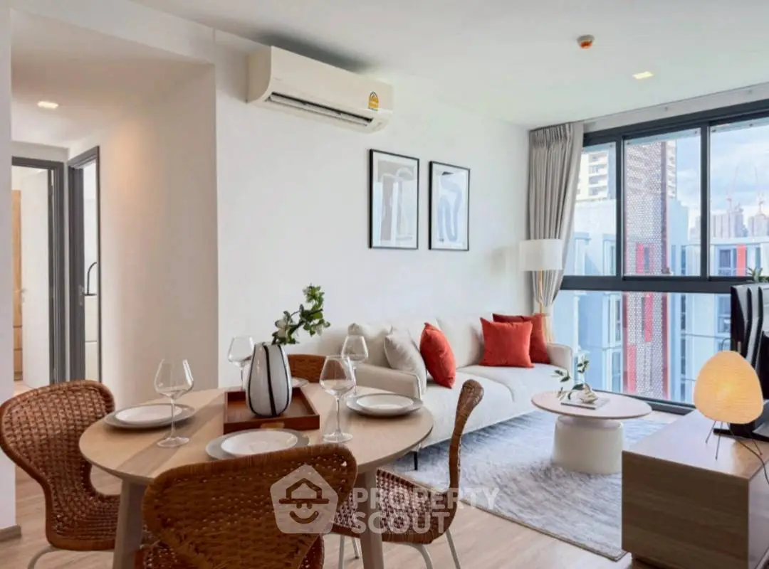 Modern living room with stylish decor and dining area in a bright apartment.