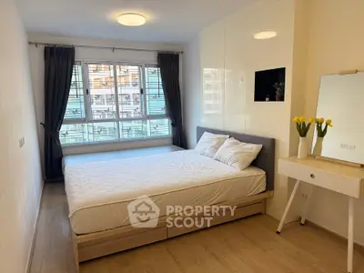Modern bedroom with large window and stylish decor in a bright apartment.