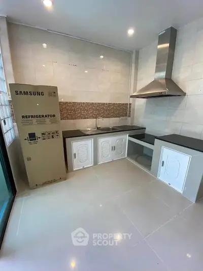 Modern kitchen with sleek cabinetry and new Samsung refrigerator in a stylish open layout.