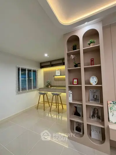 Stylish modern living room with elegant shelving and cozy seating area, perfect for relaxation and reading.