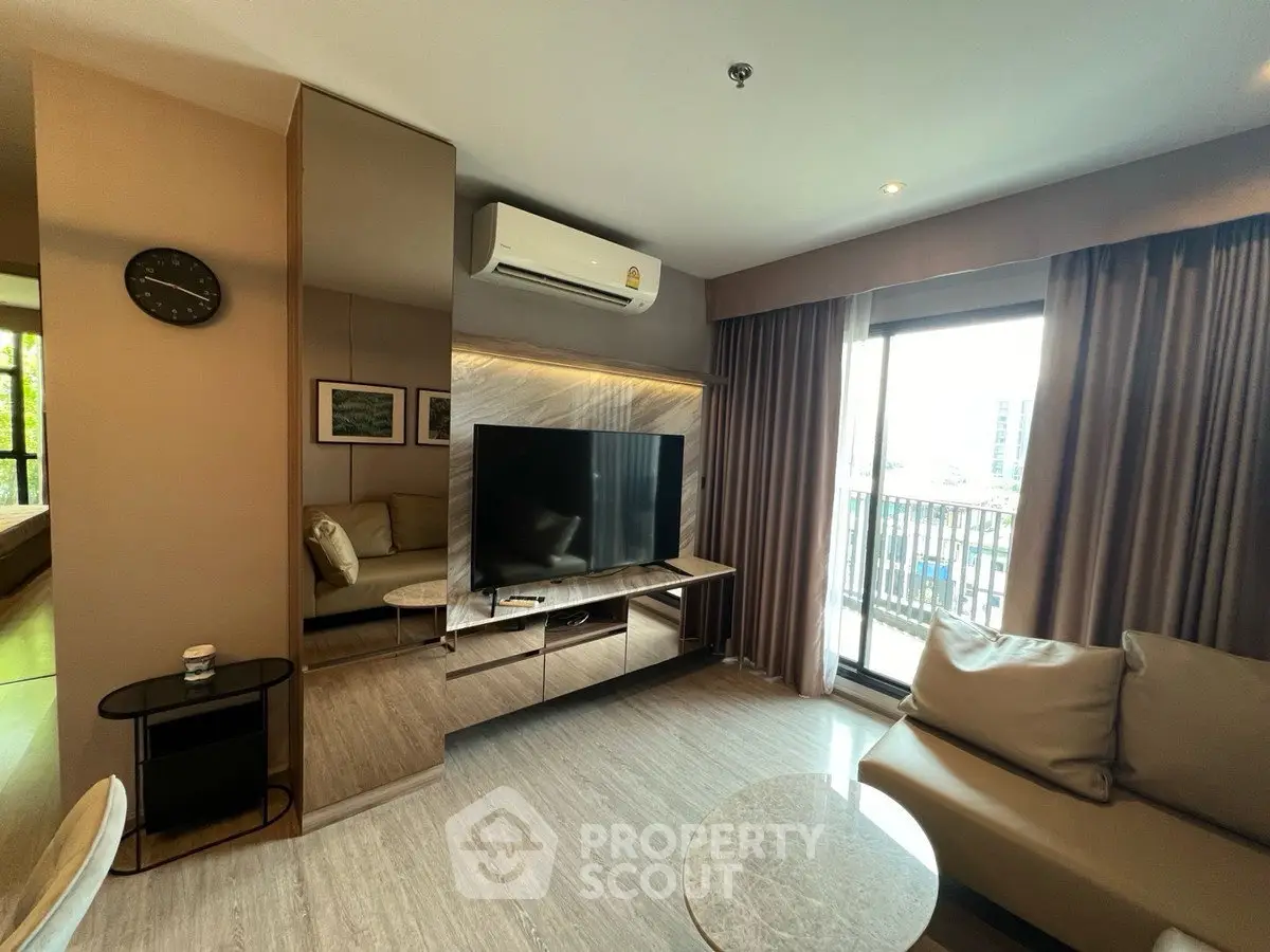 Modern living room with large TV, air conditioning, and balcony view in a stylish apartment.