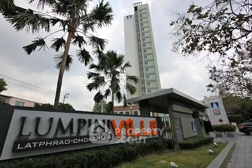 Modern high-rise building with lush landscaping at Lumpini Ville, prime urban location.