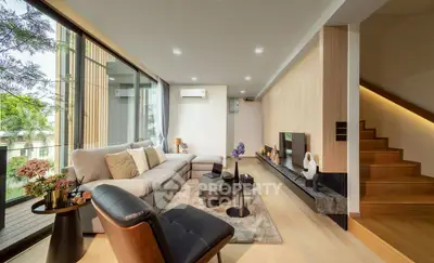 Luxurious modern living room with elegant decor and large windows offering natural light.