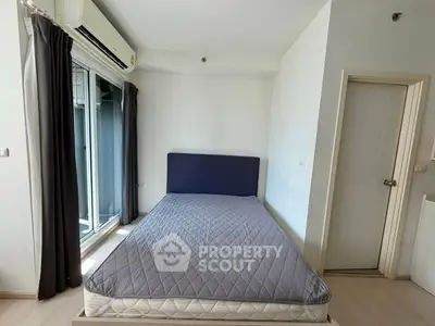 Spacious bedroom with large window and modern air conditioning unit