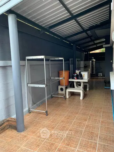 Covered outdoor area with tiled flooring and storage space