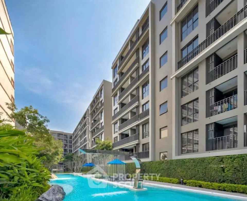 Luxurious modern apartment complex with stunning pool and lush greenery