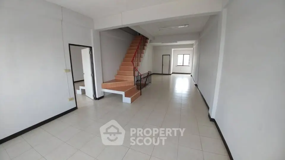 Spacious open-plan living area with staircase, ideal for modern living.