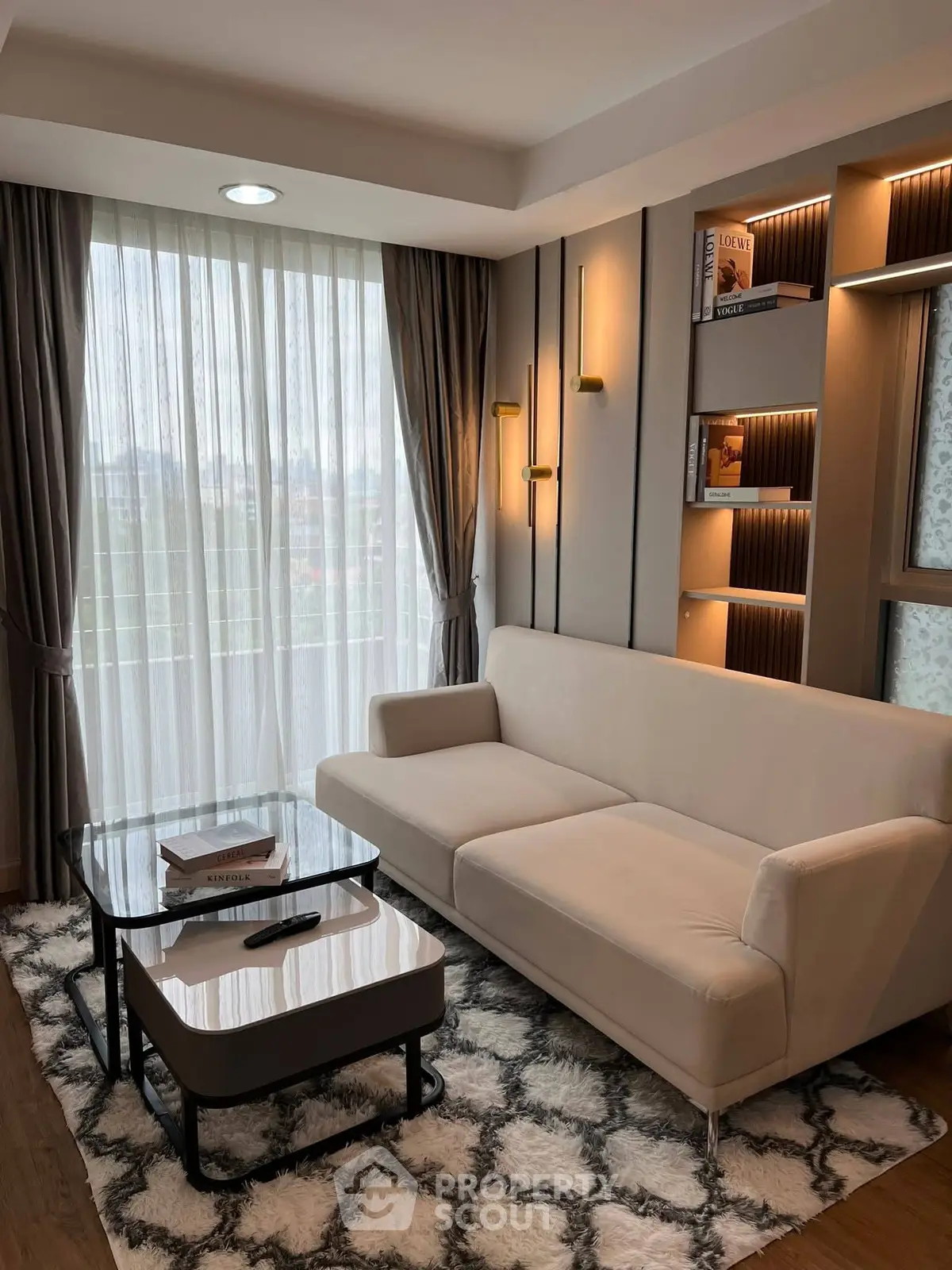 Elegant living room with modern sofa, stylish lighting, and floor-to-ceiling windows.