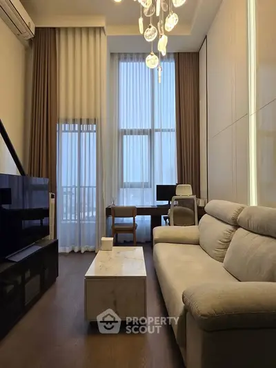 Modern living room with high ceilings, elegant chandelier, and stylish furniture, perfect for urban living.