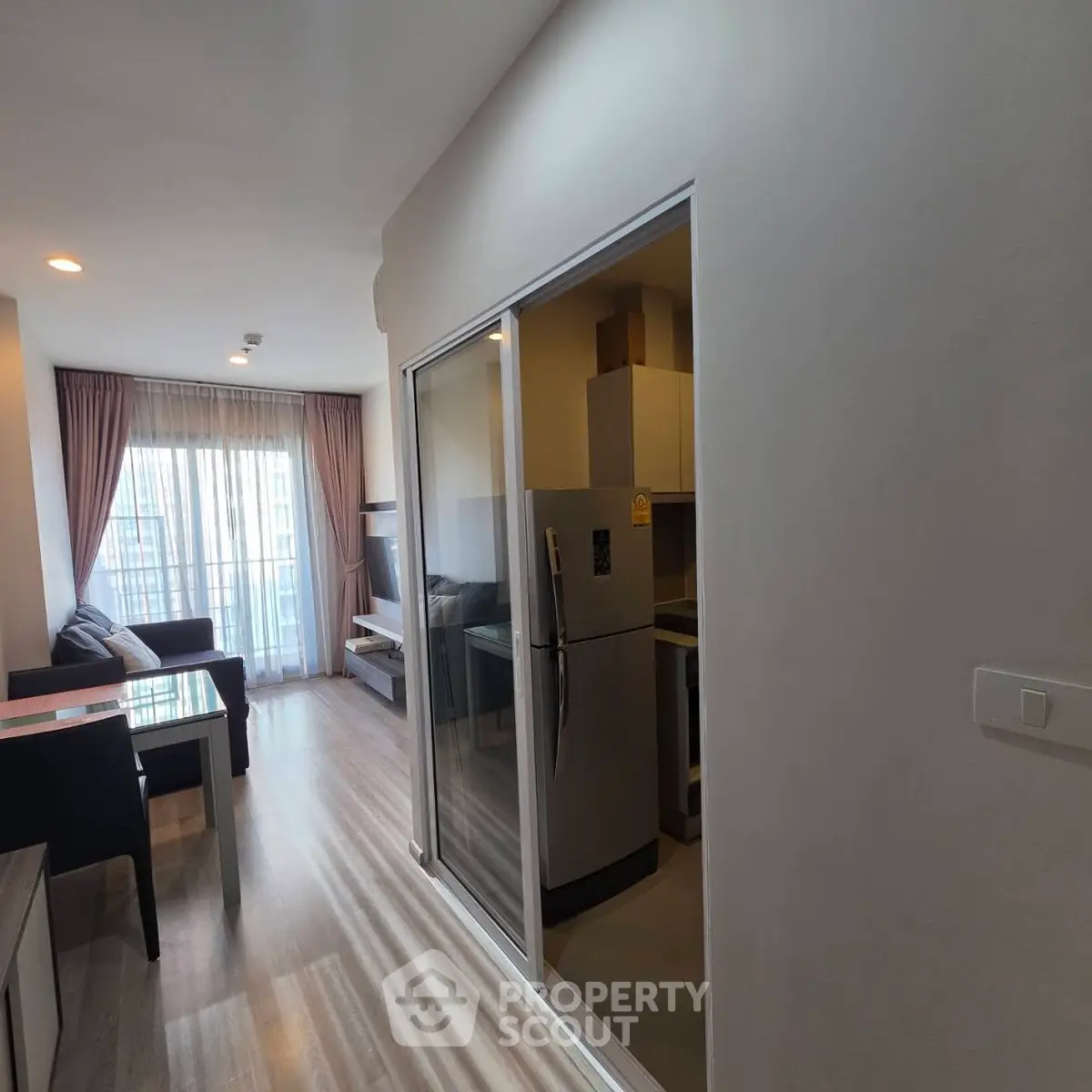 Modern apartment interior with open layout and natural light, featuring a cozy living area and sleek kitchen.