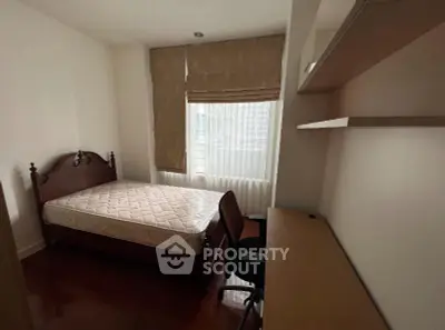 Cozy bedroom with natural light, featuring a comfortable bed and a study desk, ideal for urban living.
