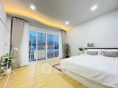 Spacious bedroom with elegant lighting and large windows offering natural light.