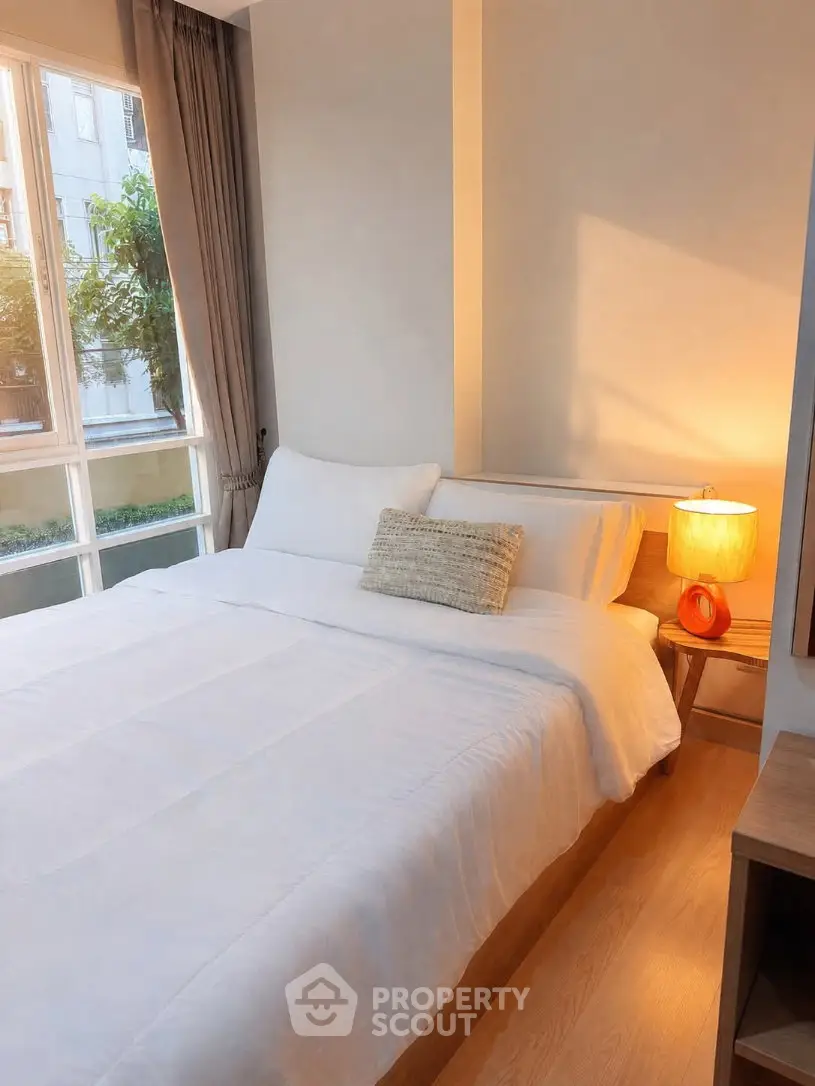 Cozy bedroom with large window and warm lighting in modern apartment
