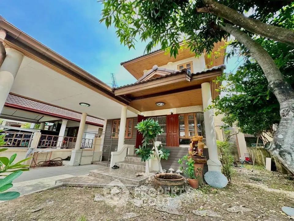 Charming two-story house with lush garden and inviting entrance