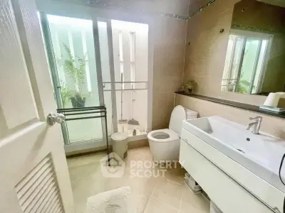 Modern bathroom with sleek fixtures and natural light from large window.