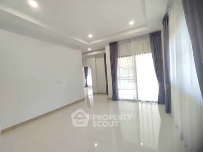 Spacious empty room with large windows and elegant curtains, perfect for customization.