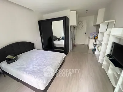 Modern bedroom with sleek black wardrobe and cozy bed in stylish apartment