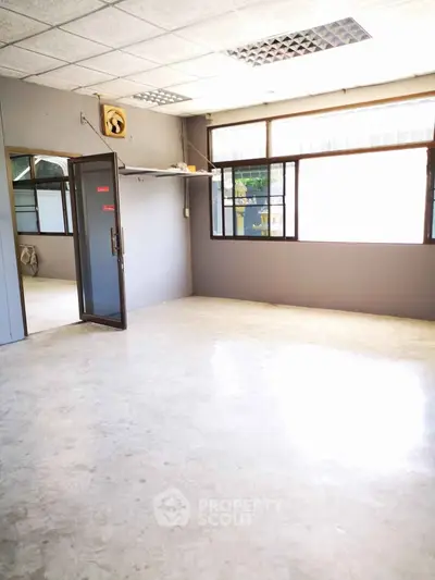 Spacious empty room with large windows and natural light