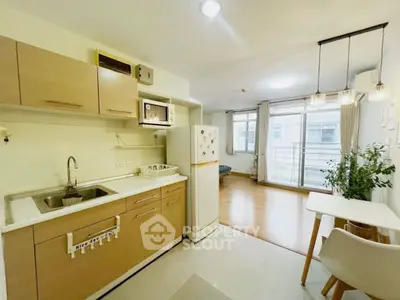 Modern open-layout kitchen with wooden cabinets and bright living area in a cozy apartment.