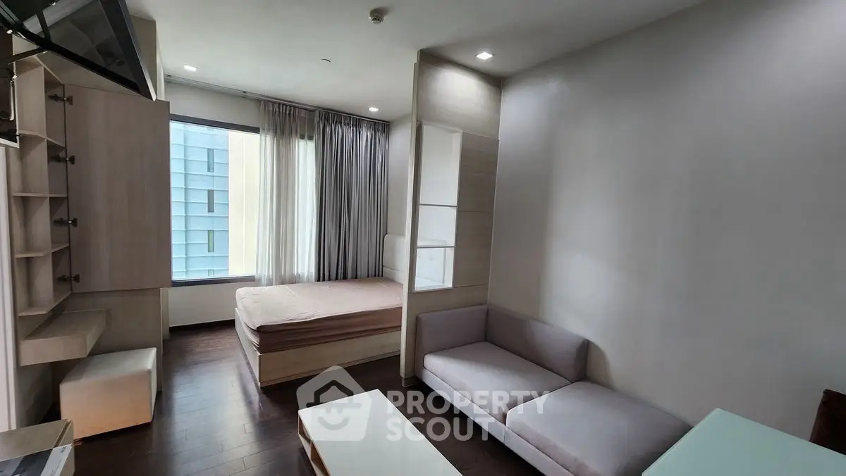 Modern studio apartment with cozy living area and large window view