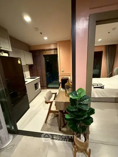 Modern open-plan kitchen and dining area with cozy bedroom view