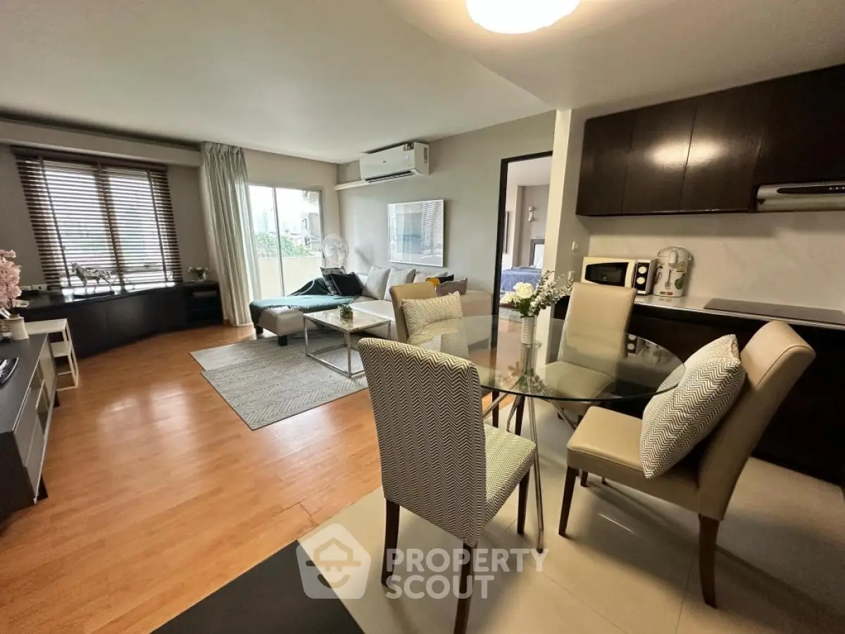 Modern open-plan living room with dining area and kitchen, featuring stylish decor and natural light.