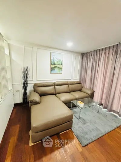 Cozy living room with modern brown leather sofa and glass coffee table, perfect for relaxation.