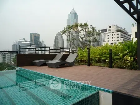 Luxurious rooftop pool with stunning city skyline views and modern lounge chairs.