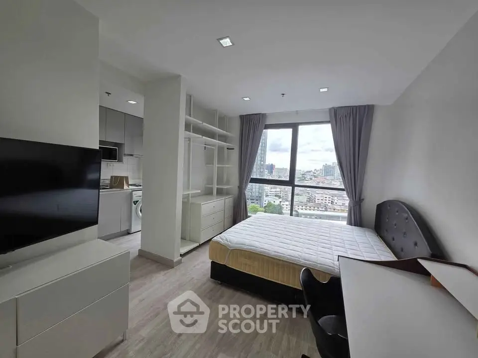 Modern bedroom with city view, featuring sleek furniture and open layout for a comfortable living experience.