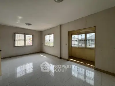 Spacious empty room with tiled flooring and large windows for natural light