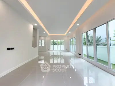Spacious modern living room with large windows and glossy tile flooring