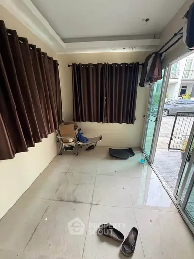 Cozy room with large windows and brown curtains, perfect for a small living space.