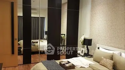 Luxurious bedroom with elegant decor and mirrored wardrobe doors