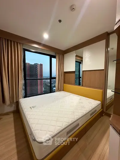 Modern bedroom with large window and city view, featuring a comfortable bed and stylish decor.