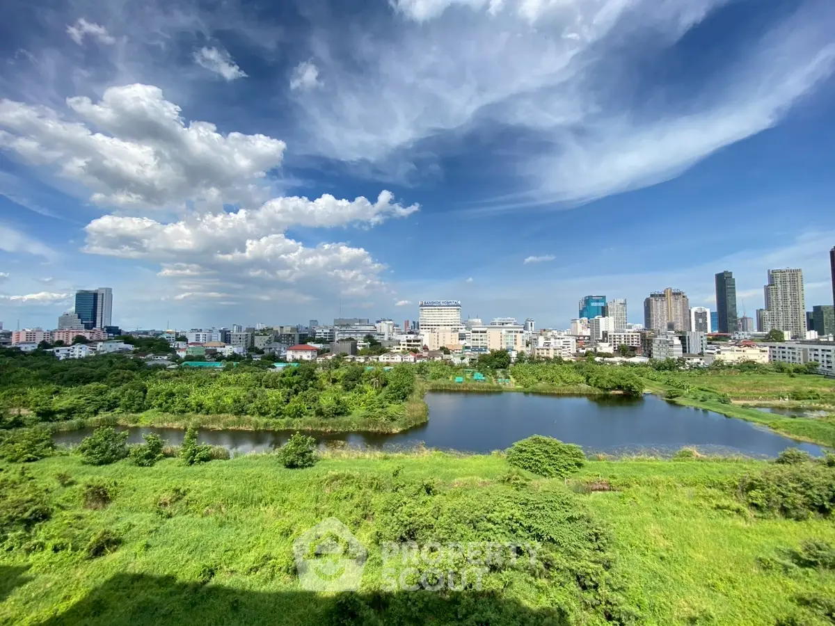 Stunning cityscape view with lush greenery and skyline under a vibrant blue sky.