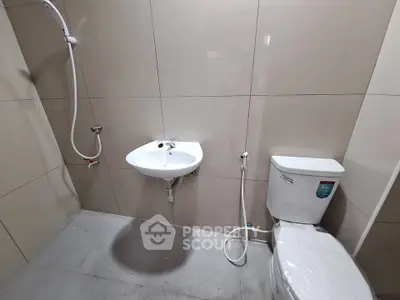 Modern bathroom with shower, sink, and toilet in minimalist design.