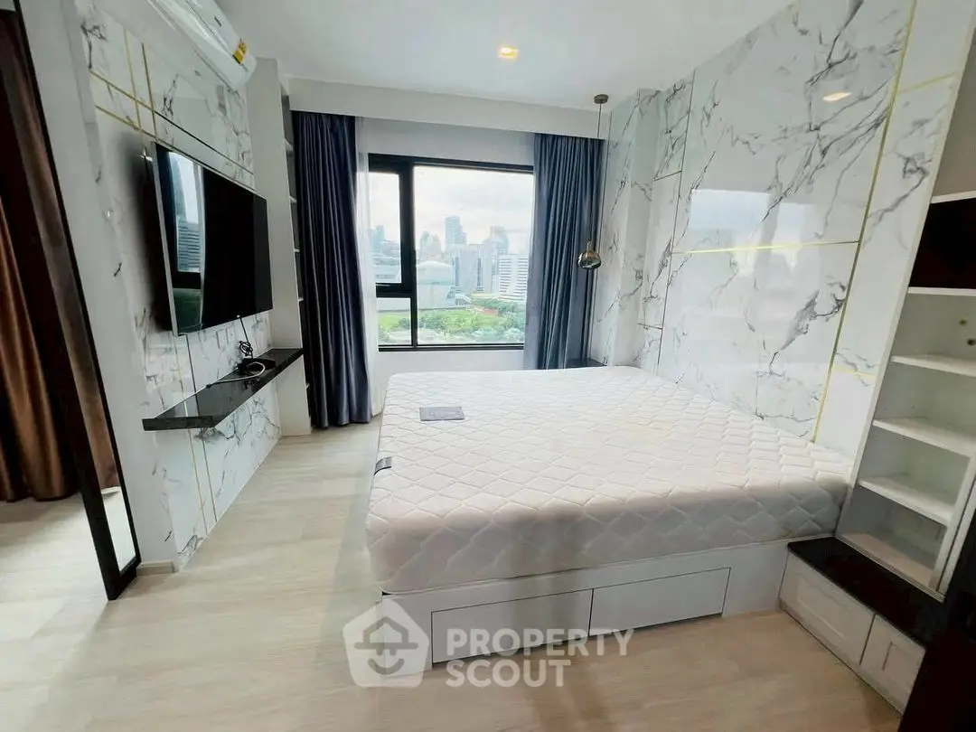 Modern bedroom with city view, marble walls, and sleek furnishings in a high-rise apartment.