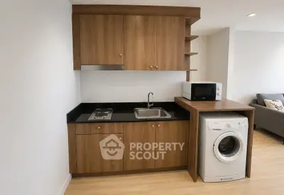Modern compact kitchen with wooden cabinets and built-in washing machine