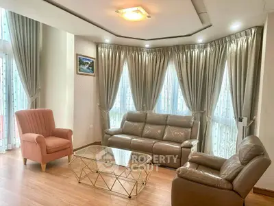 Elegant living room with leather sofas, armchair, and modern glass coffee table.