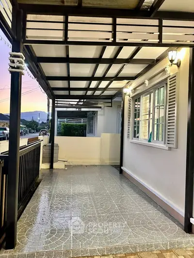 Charming covered patio with stylish tiled flooring and elegant lighting, perfect for outdoor relaxation.