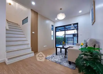 Modern living room with stylish decor and staircase, featuring cozy seating and natural light.