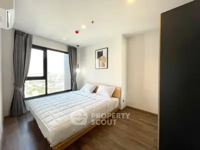 Modern bedroom with large window and stylish decor in high-rise apartment