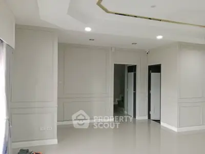 Spacious modern living room with elegant wall paneling and recessed lighting