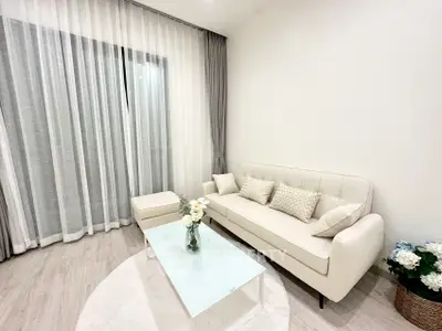 Elegant living room with modern white sofa and glass coffee table, perfect for cozy gatherings.