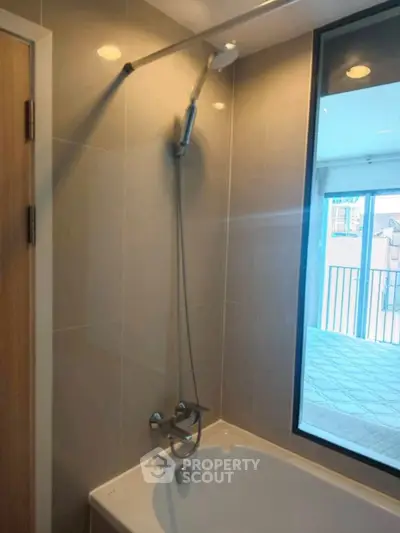 Modern bathroom with bathtub and large window offering city view.