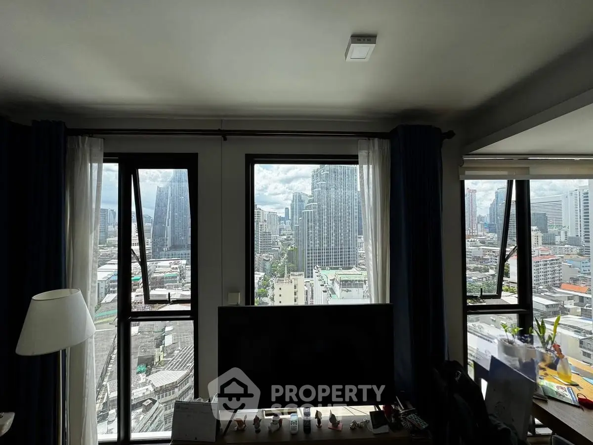 Stunning cityscape view from a modern apartment living room with large windows.